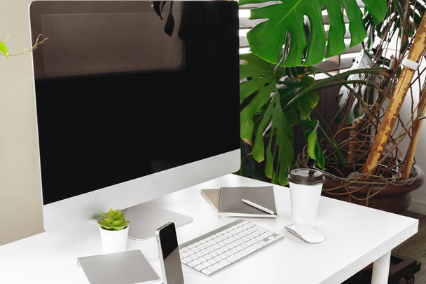 Espaço de trabalho elegante com computador, teclado, material de escritório e planta no escritório moderno
 - Foto, Imagem