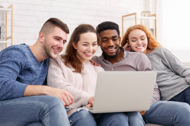 Группа друзей наслаждается временем вместе и смотрит на ноутбук
 - Фото, изображение