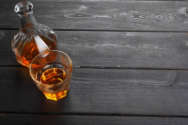 bottle and glass of whiskey on a wooden background - Foto, Imagem