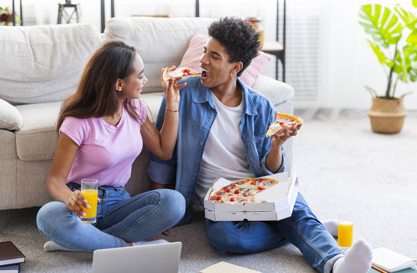 Couple joyeux manger de la pizza et prendre des boissons à la maison
 - Photo, image
