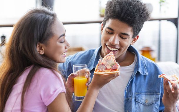 Lovely african american couple sharing pizza on date at home - Foto, immagini