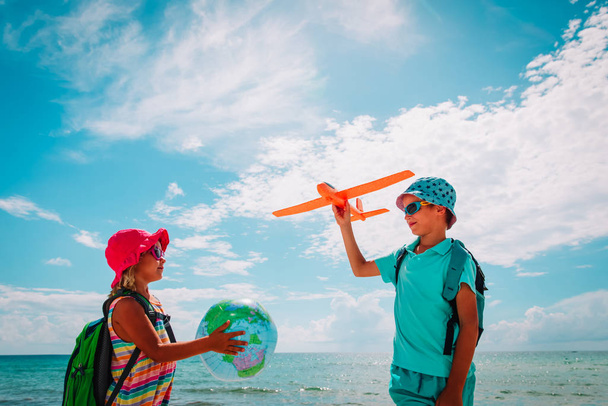 çocuklar sahilde seyahat, dünya ve oyuncak uçak ile erkek ve kız - Fotoğraf, Görsel