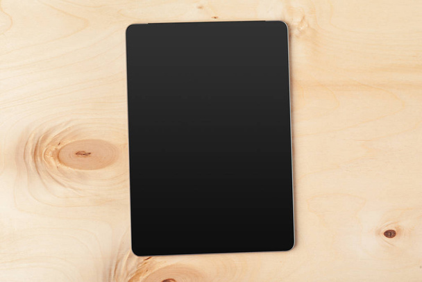 digital tablet on wooden table - Foto, afbeelding