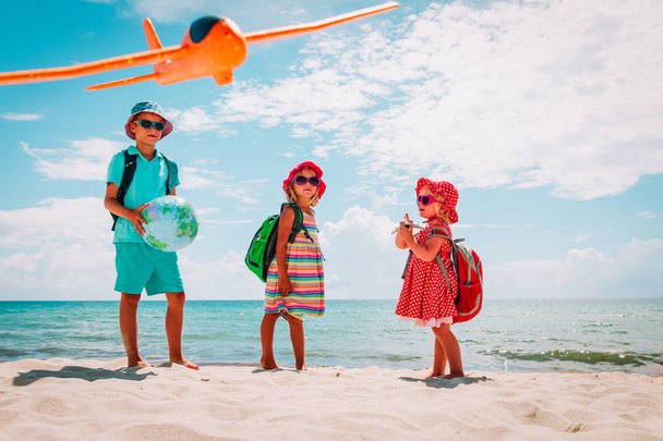 lapset matkustaa rannalla, poika ja tytöt maapallo, lelu kone ja kiikarit
 - Valokuva, kuva