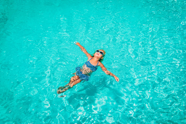 bambina rilassarsi in acqua sulla spiaggia o in piscina, vacanza - Foto, immagini