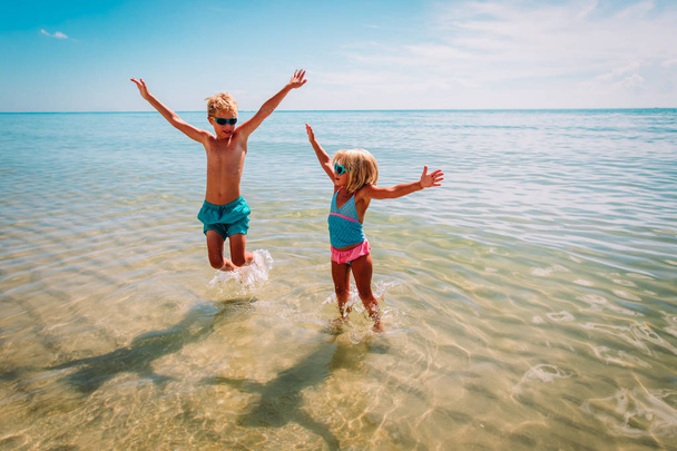 幸せな子供 - 女の子と男の子 - ビーチで波と遊ぶ - 写真・画像