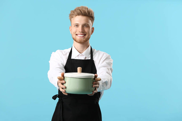 Handsome male chef with soup on color background - Photo, Image