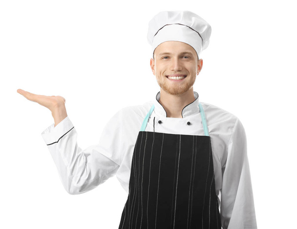 Pohledný mužský šéfkuchař zobrazující něco na bílém pozadí - Fotografie, Obrázek