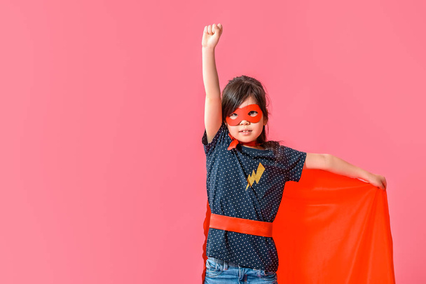 Schattig klein meisje gekleed als superheld op kleur achtergrond - Foto, afbeelding