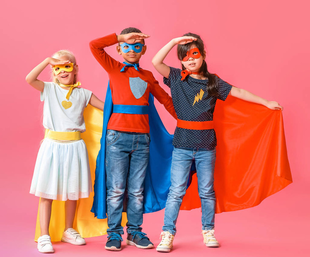 Cute little children dressed as superheroes on color background - Fotó, kép