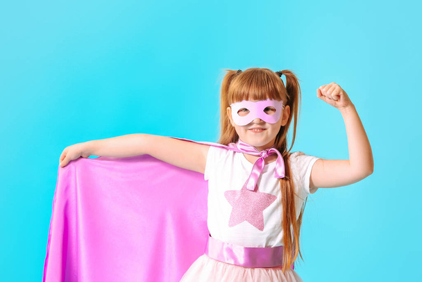 Милая маленькая девочка, одетая как супергерой на цветном фоне
 - Фото, изображение