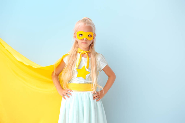 Renkli arka planda süper kahraman gibi giyinmiş sevimli küçük kız - Fotoğraf, Görsel