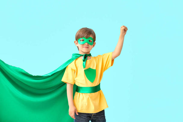Симпатичный маленький мальчик, одетый как супергерой на цветном фоне
 - Фото, изображение