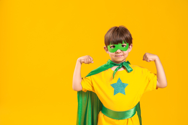 Cute little boy dressed as superhero on color background - Photo, Image