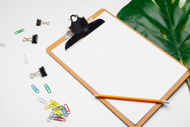 Home office workspace mockup with clipboard, palm leaf and accessories. Flat lay, top view - Foto, imagen