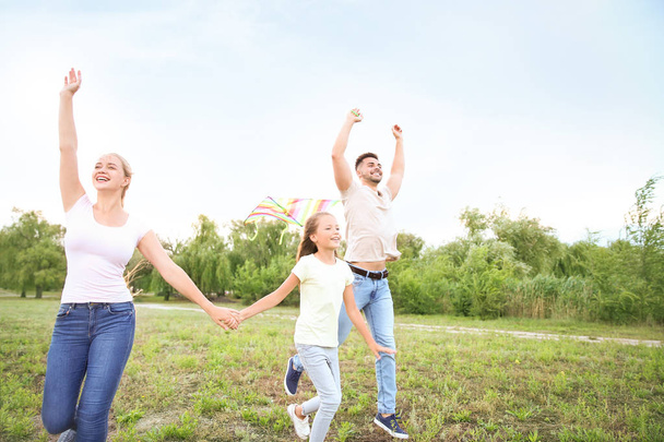 Happy family flying kite outdoors - Photo, Image