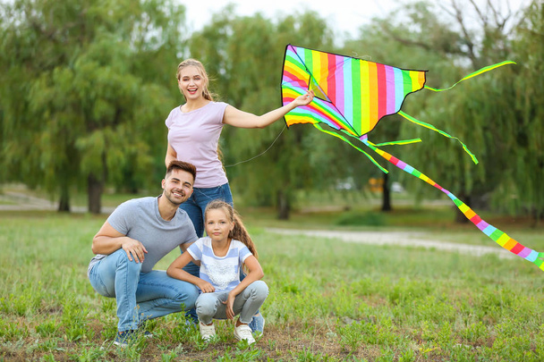 Happy family flying kite outdoors - Foto, afbeelding