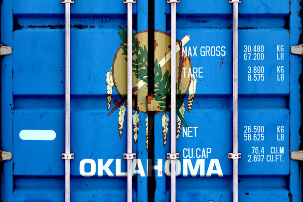 The national flag of the US state Oklahoma in a container doors  - Photo, Image