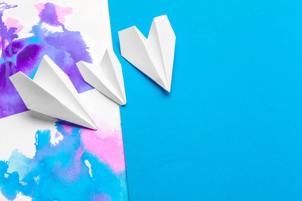 white paper airplane on a color block paper background - Foto, Imagem