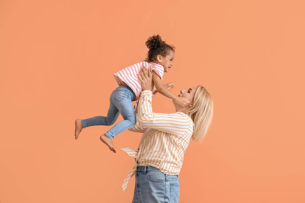Happy woman and her little African-American daughter on color background - Foto, Imagem