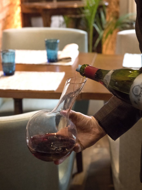 Офіціант вливає елітне червоне вино в деканер. Вертикальна орієнтація
 - Фото, зображення