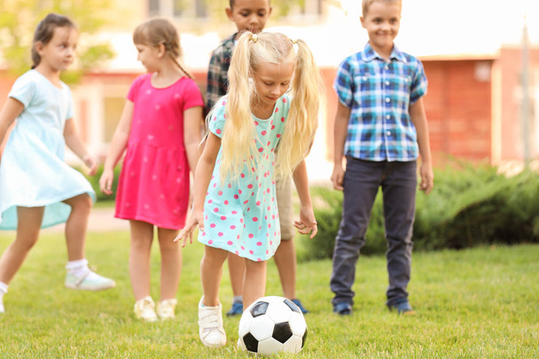 公園でサッカーをしているかわいい小さな子供たち - 写真・画像