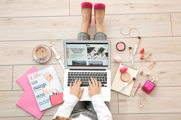 Female beauty blogger with laptop sitting on wooden floor, top view - Photo, Image