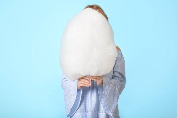 Young woman with tasty cotton candy on color background - Foto, Imagen
