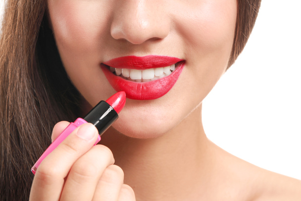 Beautiful young woman with lipstick on white background, closeup - Photo, Image