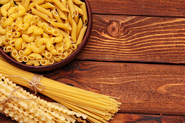 dried pasta on wooden background - Φωτογραφία, εικόνα