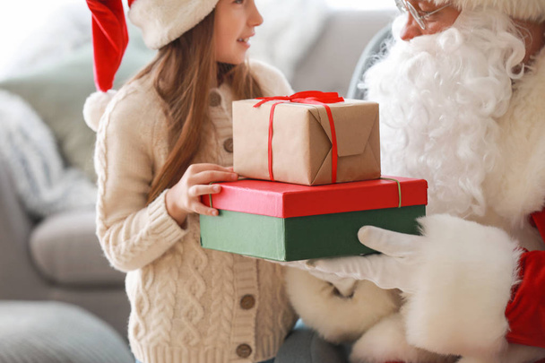 Άγιος Βασίλης και χαριτωμένο κοριτσάκι με δώρα στο δωμάτιο - Φωτογραφία, εικόνα