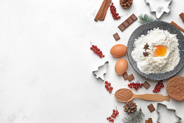 Composición navideña con cortadores de galletas e ingredientes sobre fondo blanco
 - Foto, imagen