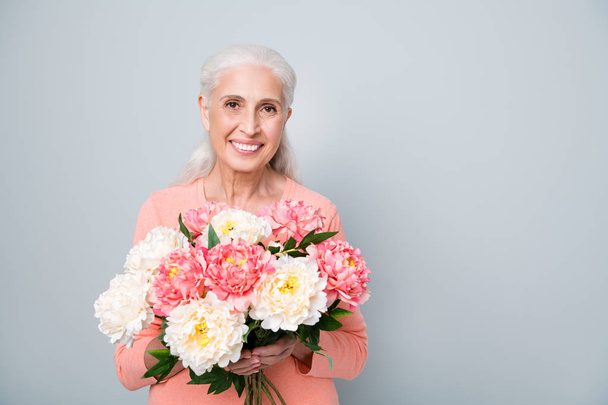 Close up photo of pretty cute sweet kind friendly sincere lady holding nice flowers in hands isolated grey background - Photo, Image