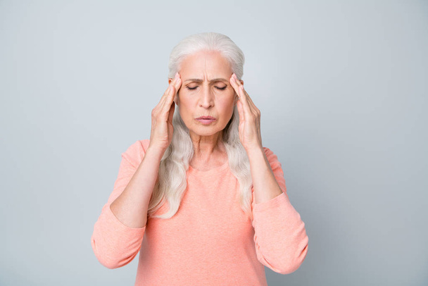 Foto de cerca de la señora de edad agotada molesto que sufre de fuerte reacción de dolor de cabeza en la tormenta magnética y el tiempo aislado fondo gris
 - Foto, Imagen