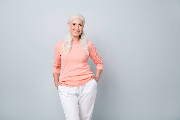 Photo studio shot of optimistic nice pretty with toothy smile old lady posing standing isolated over grey background - Fotó, kép