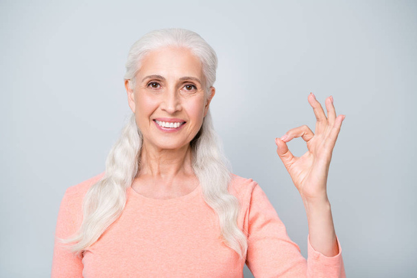 Closeup photo of kind wise old lady having wavy curly long hair making ok sign isolated grey background - Photo, Image