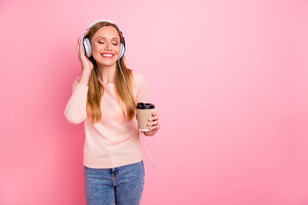 Photo of beautiful lady eyes closed listen favorite playlist earflaps takeout paper coffee wear pastel pullover isolated pink background - Photo, Image