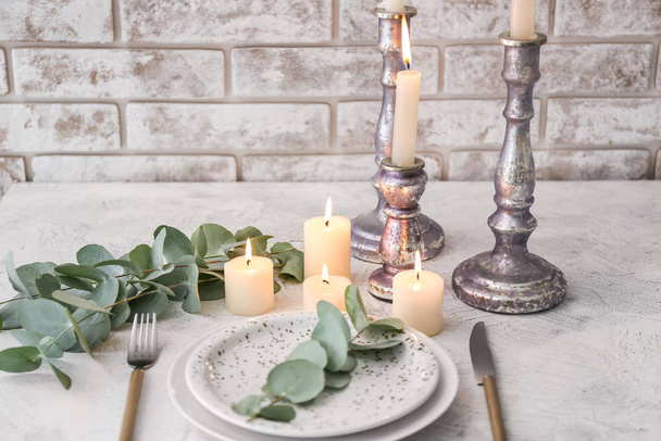 Beautiful table setting with burning candles and floral decor - Foto, Imagem