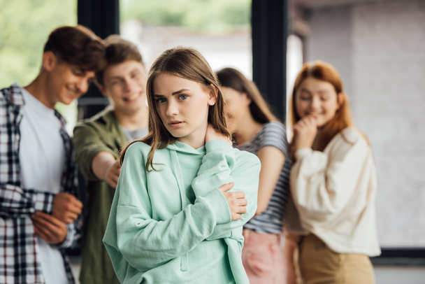 Panoramaaufnahme einer Gruppe Teenager, die Mädchen schikanieren - Foto, Bild