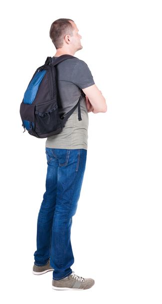 Back view of man with backpack looking up. - 写真・画像