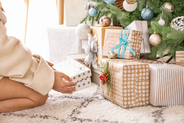 Mujer poniendo cajas de regalo bajo el árbol de Navidad - Foto, Imagen
