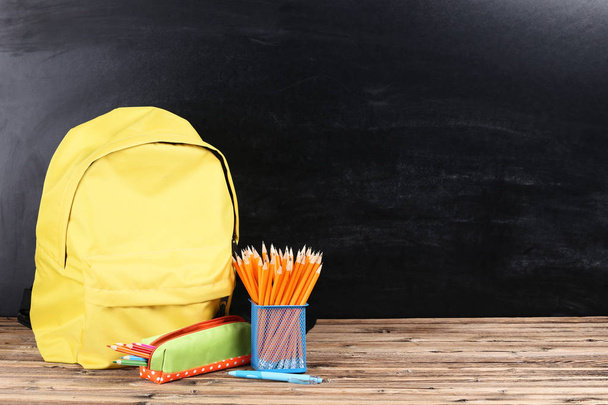 Backpack with school supplies on black background - Zdjęcie, obraz