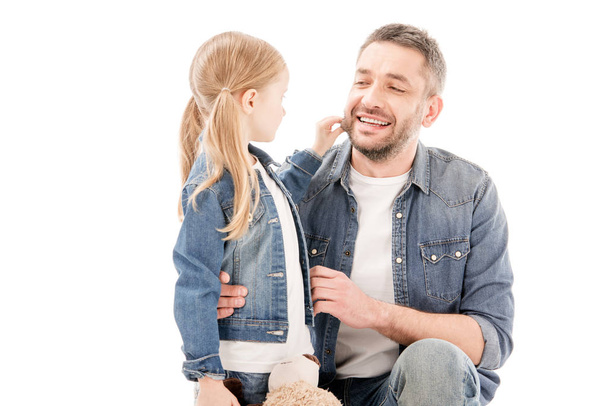 smiling dad in jeans and daughter looking at each other isolated on white - Фото, зображення