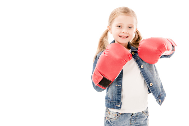 pohled na usmívající se dítě v červených boxerských rukavicích izolovaně na bílém - Fotografie, Obrázek