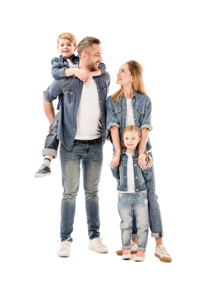 Вид в полный рост счастливой семьи в джинсах, улыбающихся изолированно на белом
 - Фото, изображение