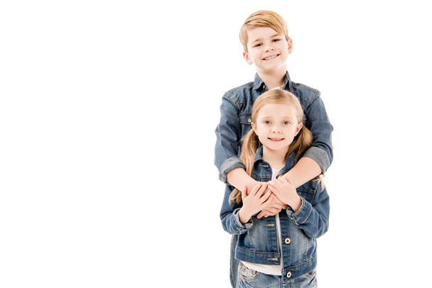 happy kids embracing and looking at camera isolated on white - Fotó, kép