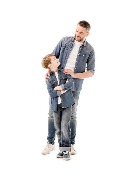 full length view of smiling father and son looking at each other isolated on white - 写真・画像