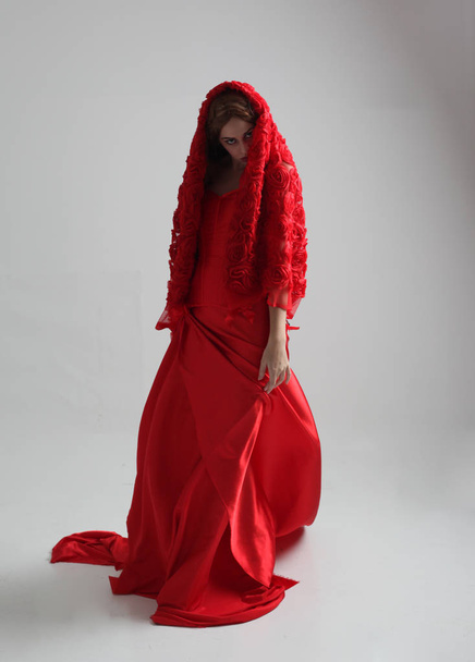 full length portrait of a  girl wearing a long red silk gown, Standing pose on a grey studio background. - Foto, immagini