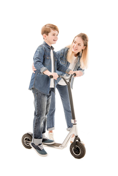 full length view of mother and son with scooter isolated on white - Zdjęcie, obraz