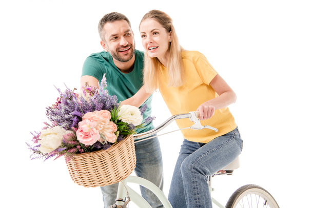 happy couple with bike and basket of flowers isolated on white - Foto, Bild